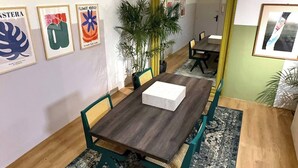 A dining area with a wooden table and chairs, a patterned rug, and framed artwork on the walls. - GroundFloor Serenity (Cairo Governorate)