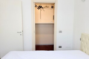 A bedroom with a bed, a wardrobe with hanging space, and a door. - SE185 - Senigallia, renovated three-room apartment with garden and garage (Senigallia)