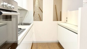 A modern kitchen with a built-in oven, a stainless steel sink, and a wooden floor. - SE185 - Senigallia, renovated three-room apartment with garden and garage (Senigallia)