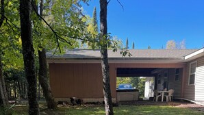 Une propriété résidentielle dotée d’un garage fermé, d’une pelouse et d’une allée bordée d’arbres.