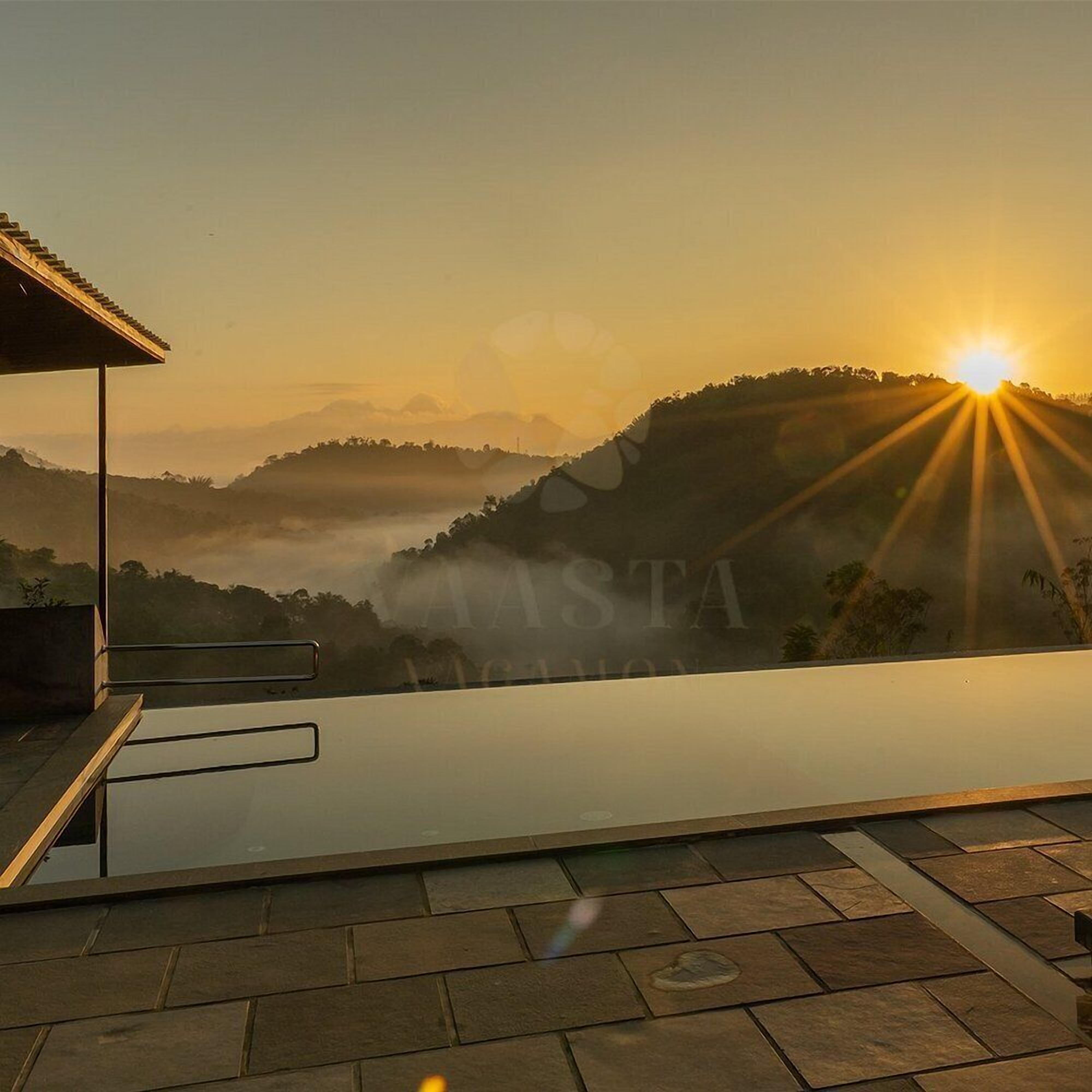 Une terrasse sur le toit offrant une vue sur le lever du soleil au-dessus d’un paysage vallonné.