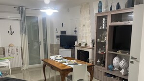Una sala de estar moderna con comedor, televisión y chimenea.