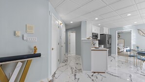 A modern kitchen with white cabinets, a marble floor, and a central island. - Stop the car! : Immediate Observation Required" (Manassas)