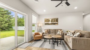 A living room with a sofa, armchair, coffee table, and a painting on the wall. - Charming 3BR Plover Townhome w/ Modern Comfort, Amenities & Style (Plover)