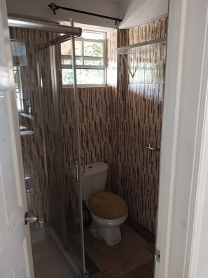 Een douche, handdoeken, zeep, toiletpapier