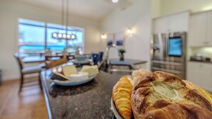 Una cocina con comedor, un ventanal grande y una encimera con pan.