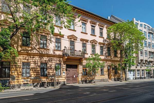 A multi-story building with a classic architectural style, featuring balconies and large windows.