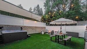 Ein Hinterhof mit Grill, Tisch und Stühlen sowie einem Zelt.