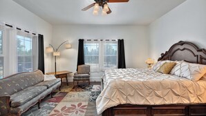 A bedroom with a bed, a sofa, a chair, a floor lamp, and a ceiling fan. - Fragrance free, 1930 2-bdrm Craftsman farmhouse on 3 acres at the edge of town (Santa Rosa)