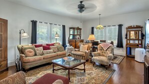 A spacious living room with a large sofa, armchairs, a coffee table, and a fireplace. - Fragrance free, 1930 2-bdrm Craftsman farmhouse on 3 acres at the edge of town (Santa Rosa)