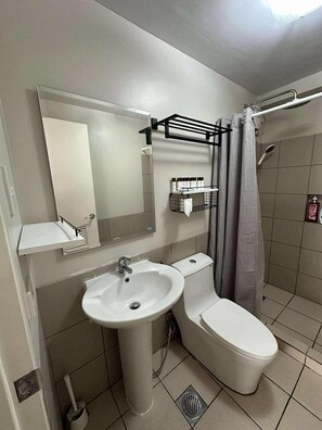 A bathroom with a sink, toilet, and shower. - Cozy  place to stay with family and friends (Quezon City)