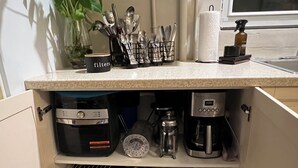 A kitchen with a coffee maker, a scale, and a container labeled "filters".