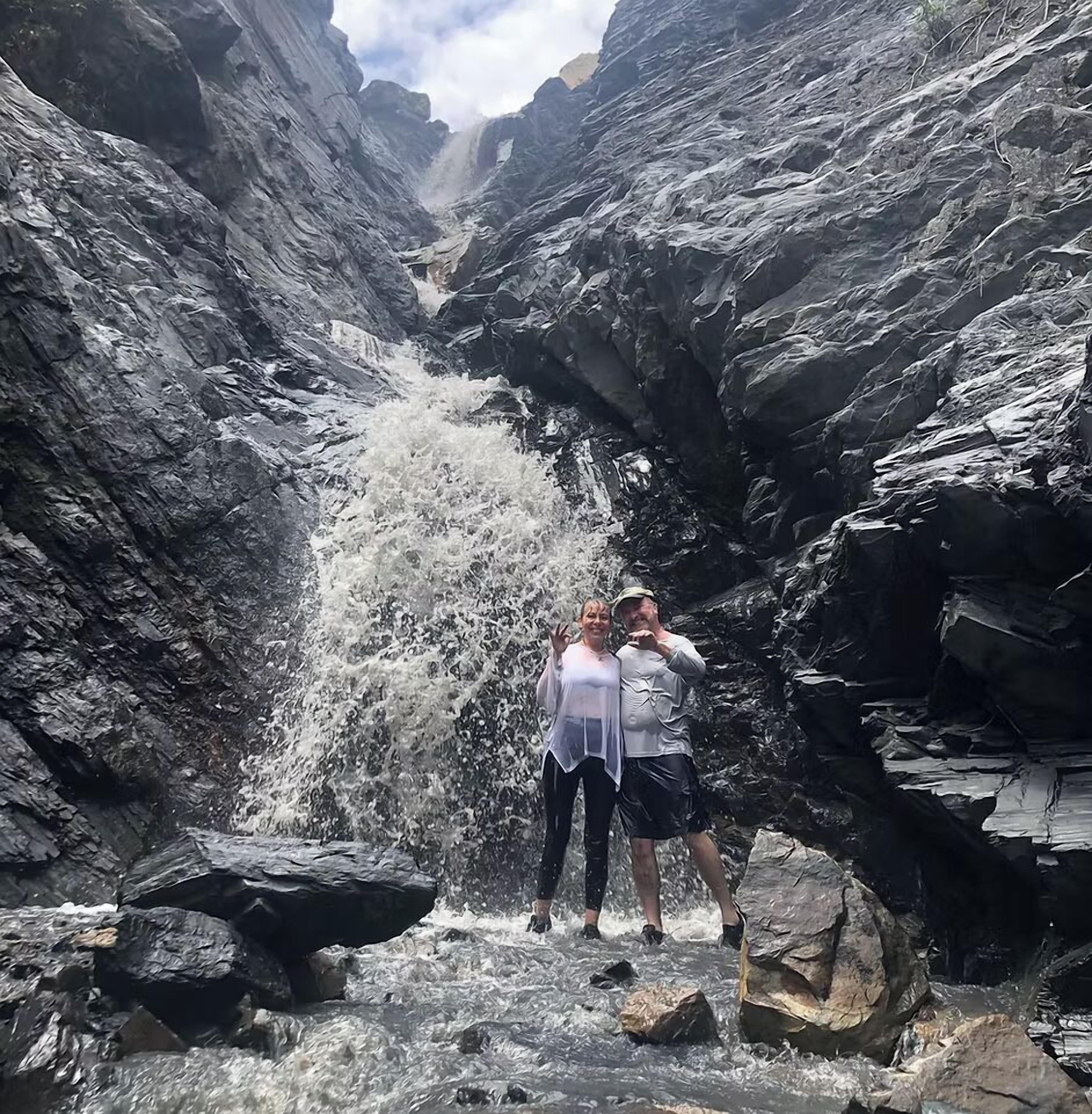 A narrow canyon with a waterfall.