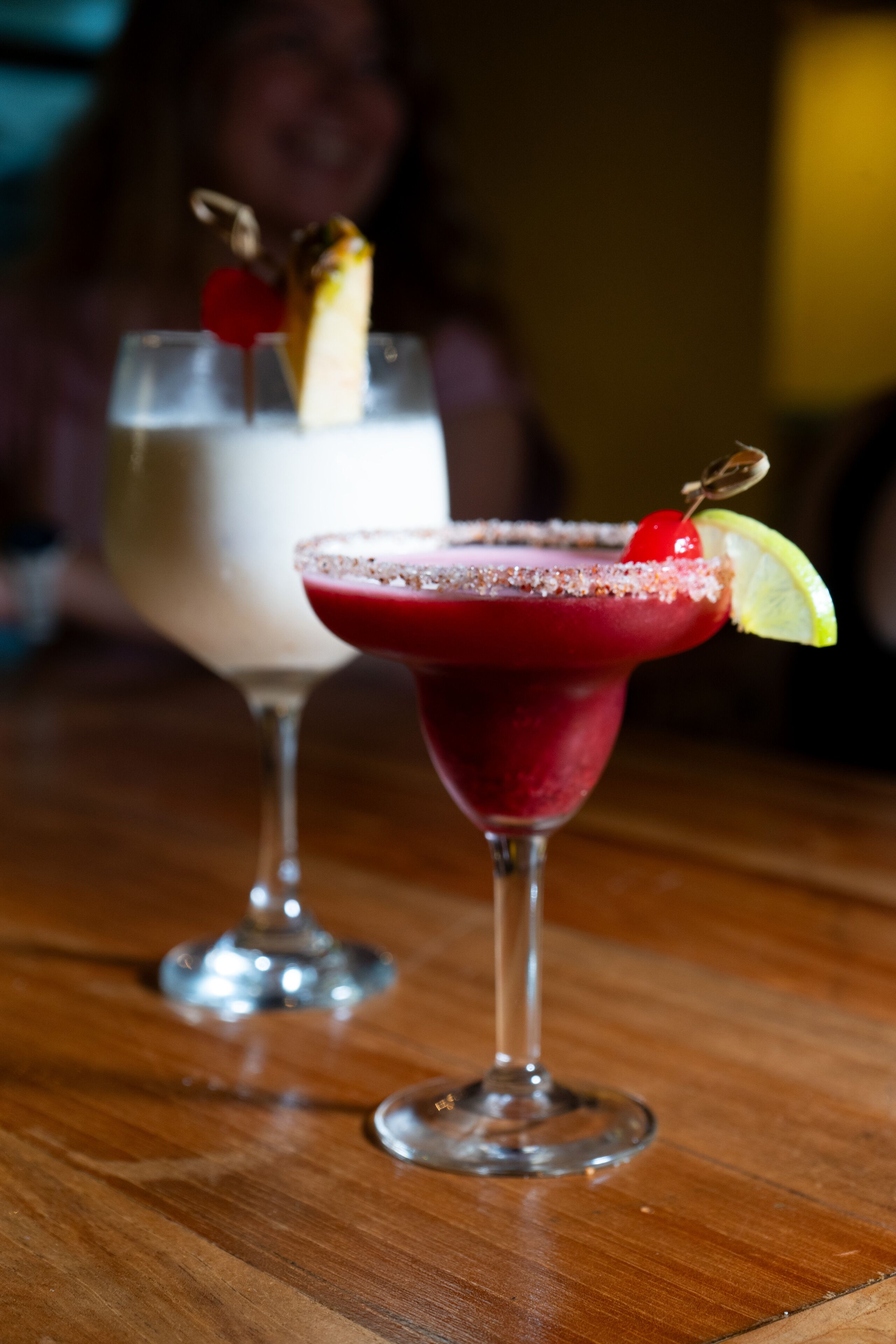Deux cocktails sur une table en bois.