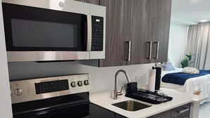 Une cuisine moderne équipée d’un four à micro-ondes, d’un four et d’une plaque de cuisson intégrés.