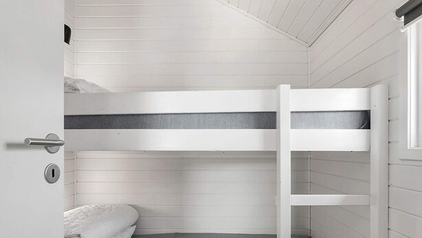 A bunk bed room with a ladder, a door with a handle, and a window.
