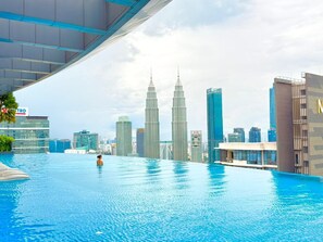 A large indoor swimming pool with a city skyline in the background, including the Petronas Towers.