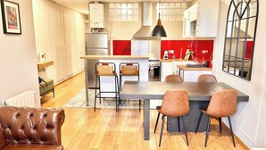 A modern kitchen with a central island, bar stools, and a dining table. - Nice apartment in Gracia neighborhood (Barcelona)