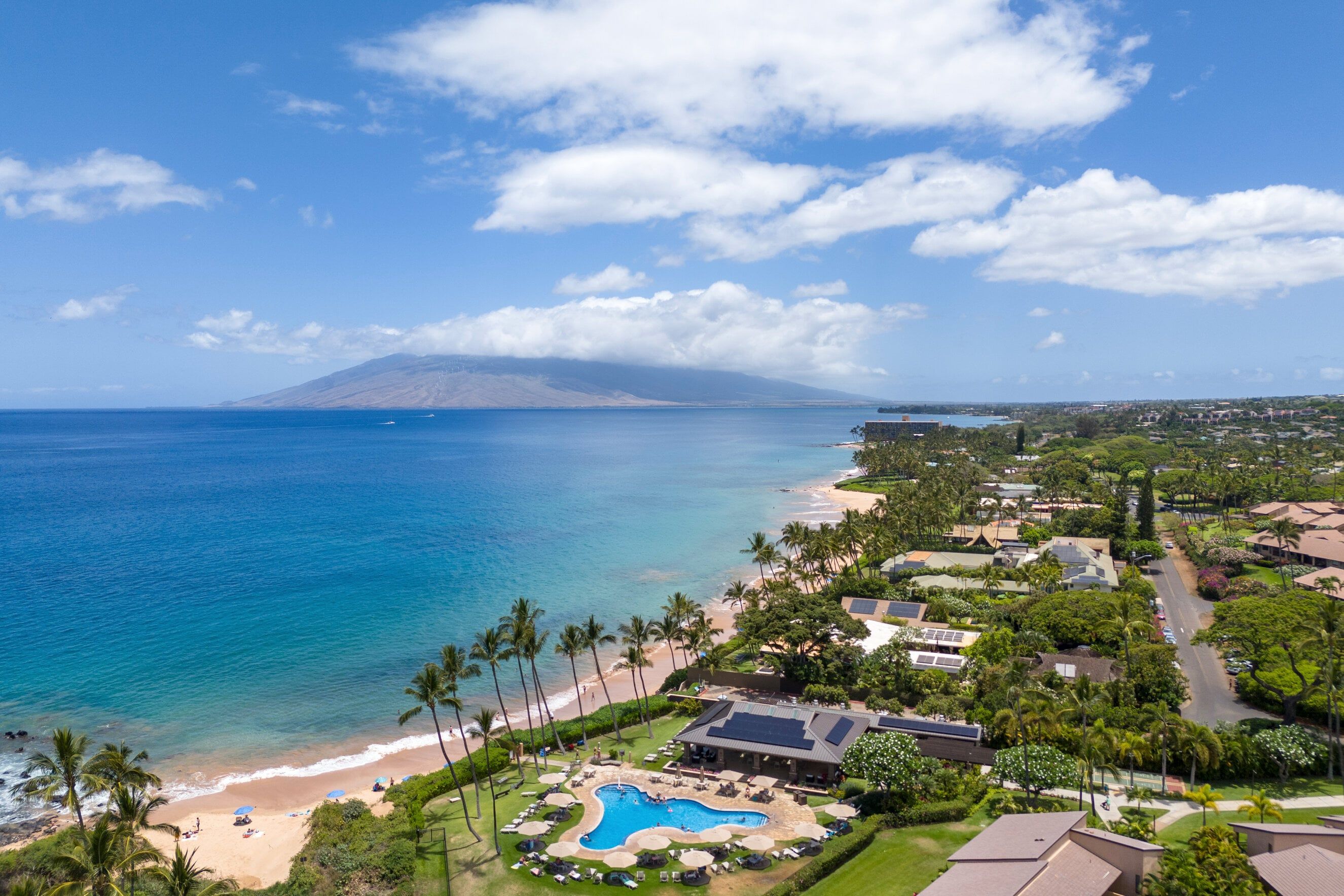 A resort with a swimming pool, beach, and ocean view.