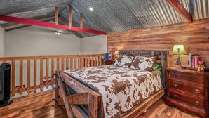 A bedroom with a wooden bed, a nightstand, a dresser, and a ceiling fan.