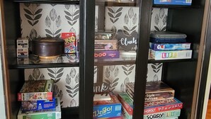 Een boekenplank met verschillende gezelschapsspellen en puzzels.