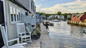 Une propriété située au bord de l’eau, dotée d’un quai, d’un vélo et d’une chaise blanche.