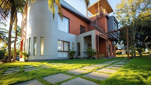 Uma casa moderna com um amplo pátio, uma escadaria e um gramado bem cuidado.