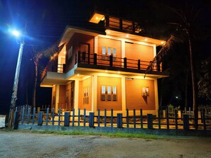 A two-story building with a balcony, a fence, and a streetlight.