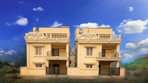 A two-story building with balconies and a gate.