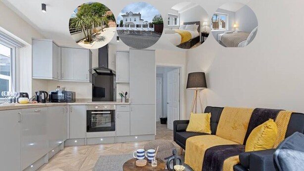A modern kitchen with white cabinets, a stove, and a dining area with a table and chairs. - Modern Apartment 2 Double Bed Free Parking Suite11 (Nottingham)