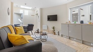 A modern living room with a sofa, coffee table, and a flat-screen TV. - Modern Apartment 2 Double Bed Free Parking Suite11 (Nottingham)