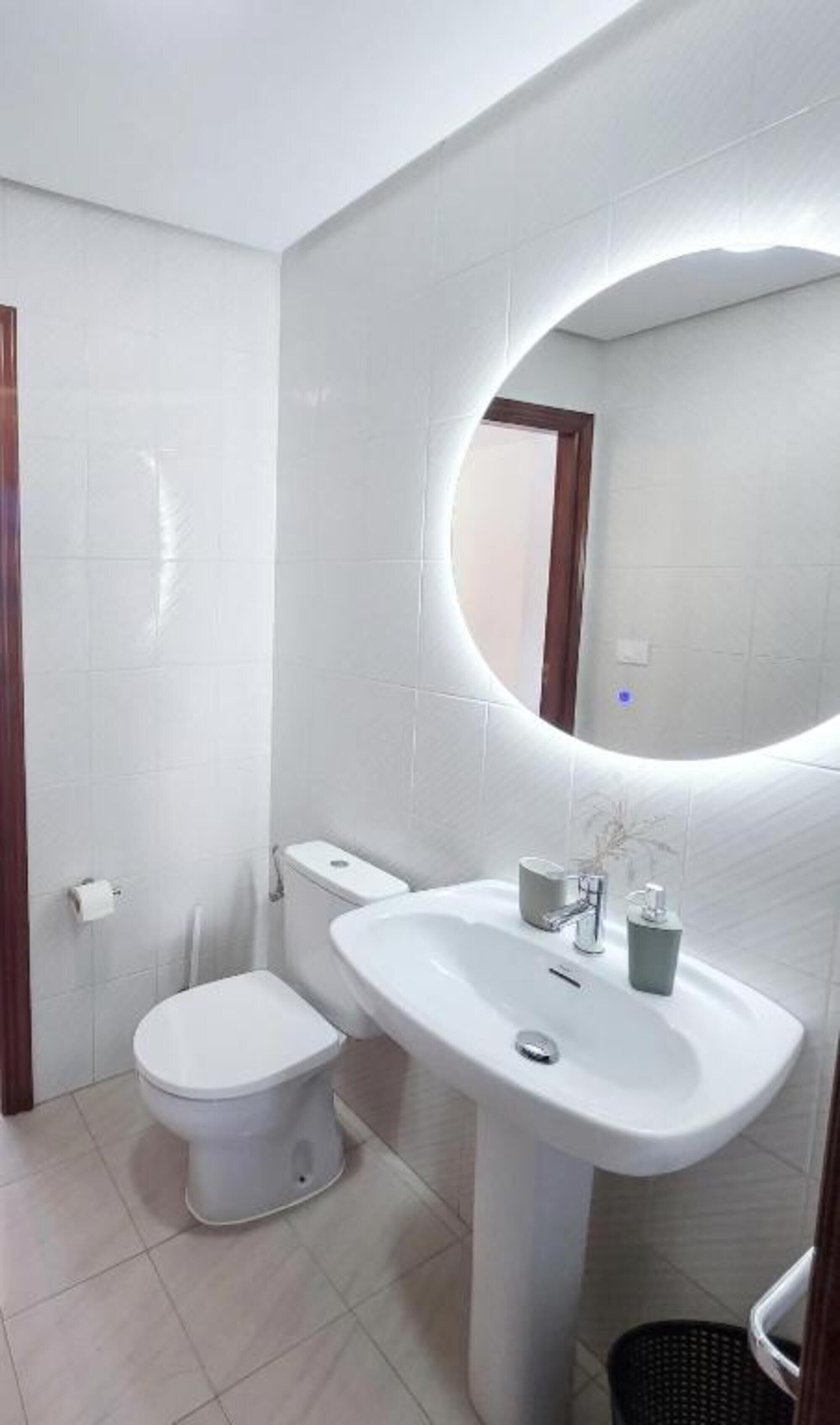 Ein Badezimmer mit Toilette, Waschbecken und Spiegel.