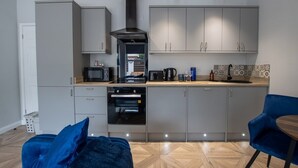 A modern kitchen with grey cabinets, a built-in oven, and a coffee machine. - Modern Apartment |King Bed |Free Parking Suite 2 (Nottingham)