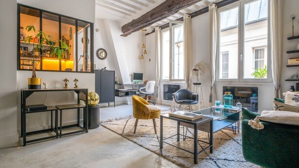 A modern living room with a large window, a sofa, a coffee table, and a desk with a computer. - Cocon Quarters - One Bedroom Villa, Sleeps 2 (Paris)