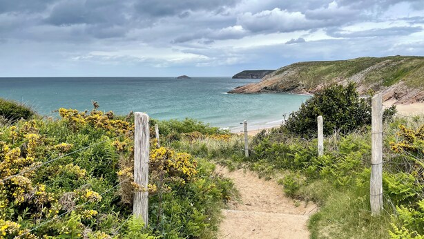 A coastal path leading to a beach with a rocky cliff and a small island in the distance. - Datcha at Cap Fréhel (Plévenon)