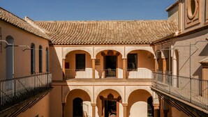 A courtyard with a tiled roof, arches, and balconies.