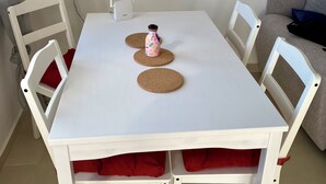 A white table with two cork placemats, a pink mug, and a white power strip with two plugs. - Superb Colina Smir apartment, swimming pool view in front of magnificent Kabila Beach (Marina Smir)