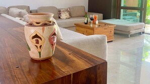 Een moderne woonkamer met een houten salontafel, een bank en een groot raam.
