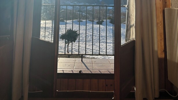 Una habitación con vista a montañas nevadas y un cielo despejado.