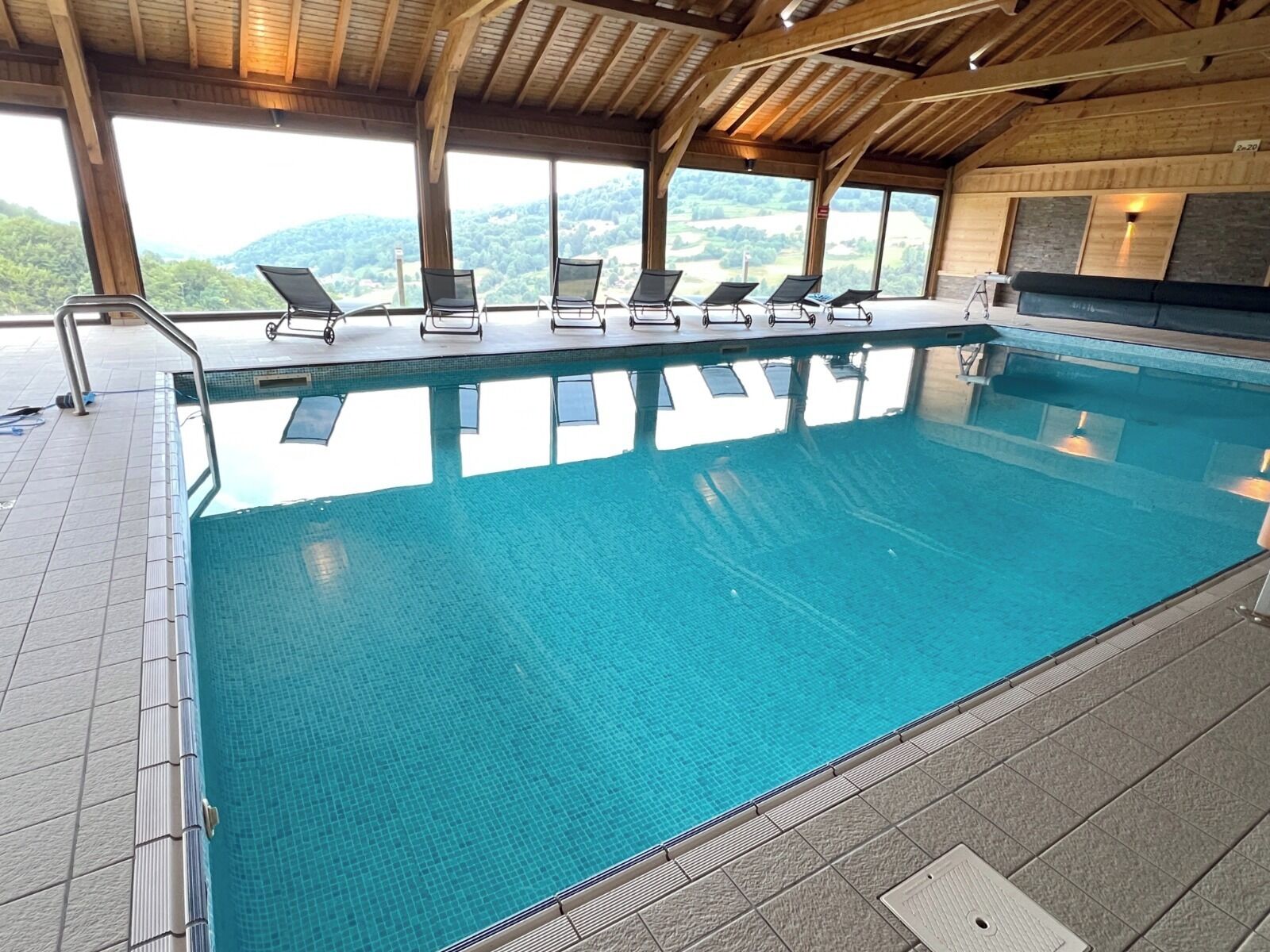 Una piscina con sillas de descanso y vistas a las montañas.