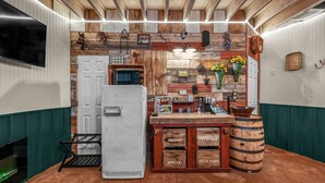 A rustic kitchen with wooden accents, a white refrigerator, and a wooden counter with labeled drawers for vegetables.