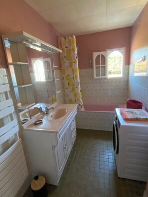 Ein Badezimmer mit Waschbecken, Spiegel und Fenster.