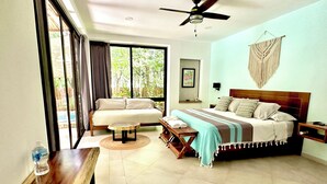 A bedroom with a bed, a sofa, a table, and a ceiling fan. - Baalamkaab Flamenco Studio (Chichimilá)
