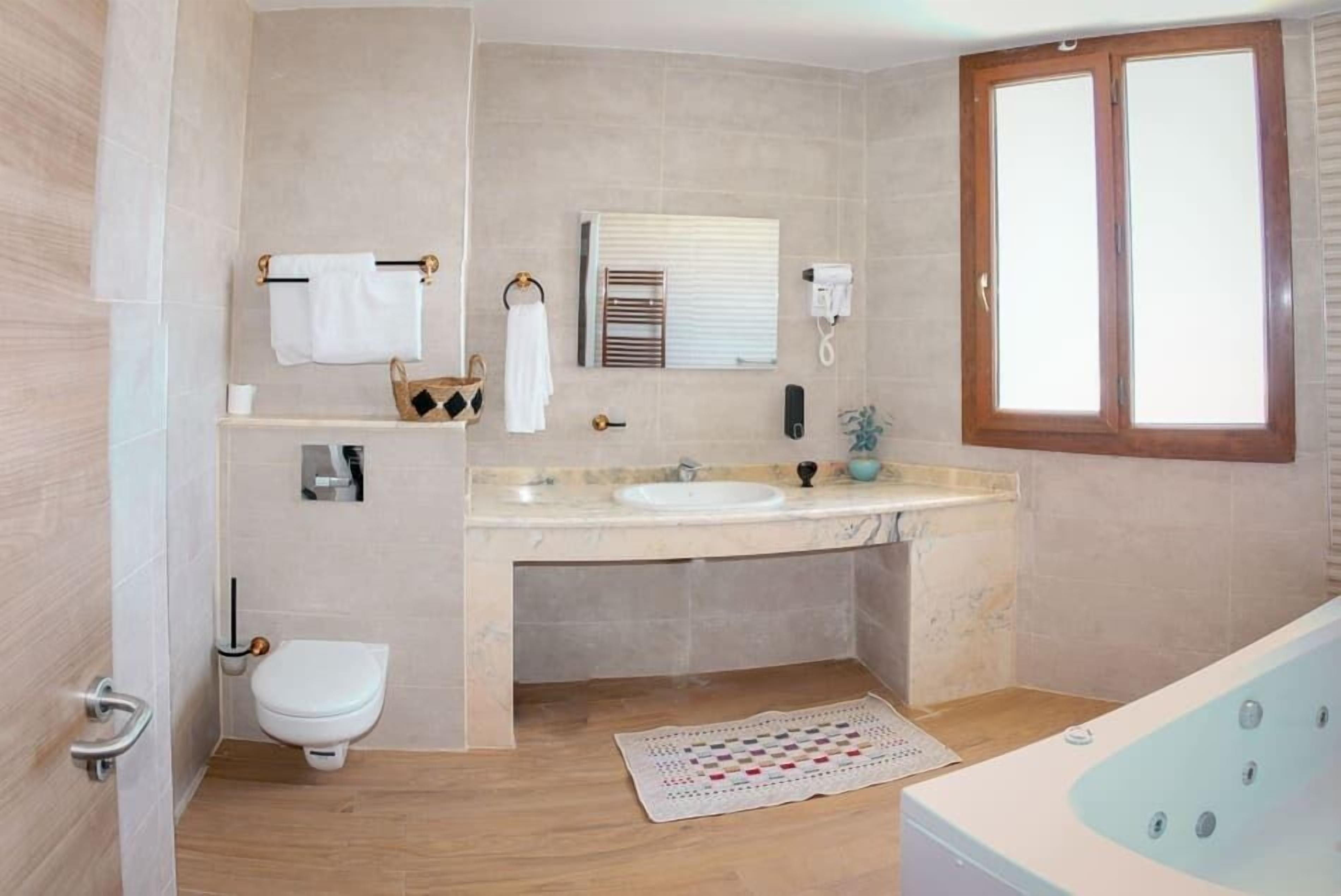 Un bagno moderno con il water, un lavandino e una vasca.