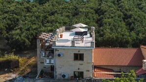 A two-story building with a rooftop terrace, a pool, and a view of a forested coastline. - Lithus Retreat with Jacuzzi  & 360° Views (ΧΑΝΙΑ)