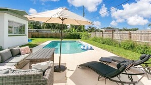 A backyard with a swimming pool, outdoor furniture, and a covered area. - Modern Poolside Bungalow in the Heart of Orlando (Orlando)