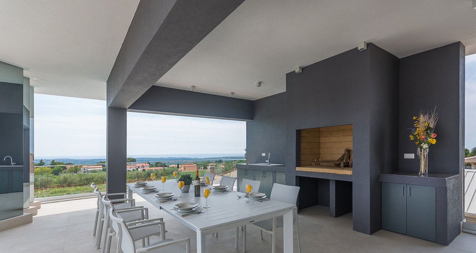 A modern outdoor dining area with a view of the countryside.