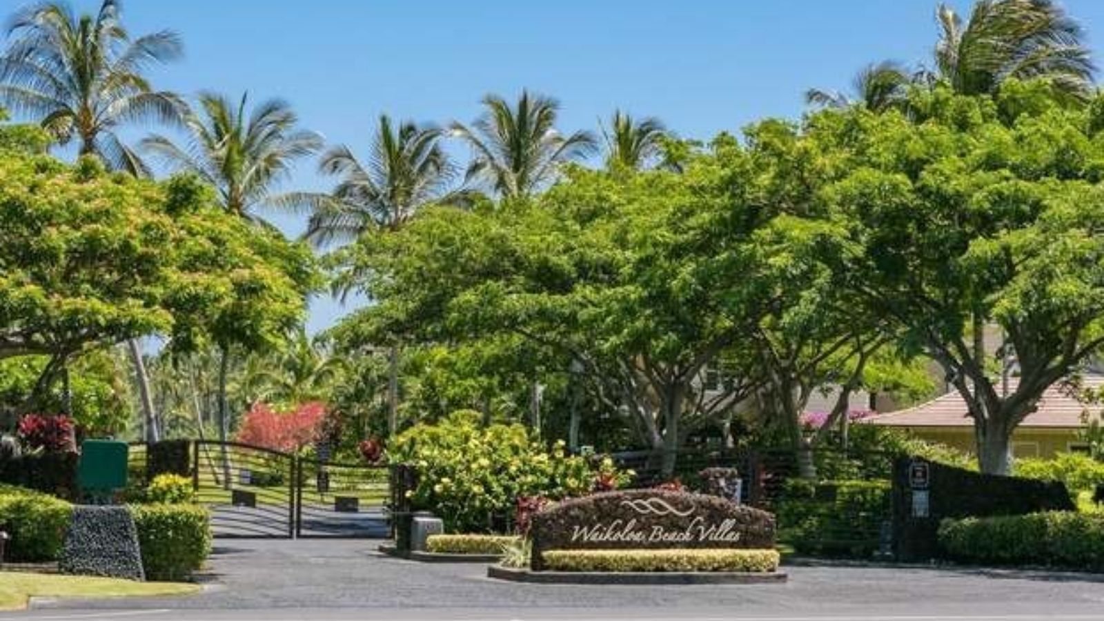 A tropical resort entrance with a sign reading "Waikoloa Beach Villas".