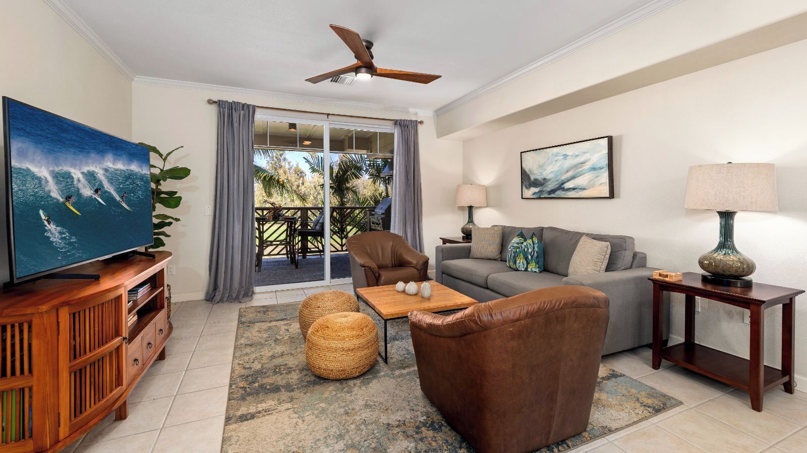 A living room with a television, sofa, coffee table, and a ceiling fan.