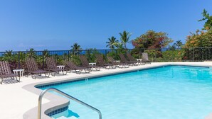 A pool area with lounge chairs and a view of the ocean. - Ocean and Golf Course Views - Pool- vrKCV (Kailua-Kona)
